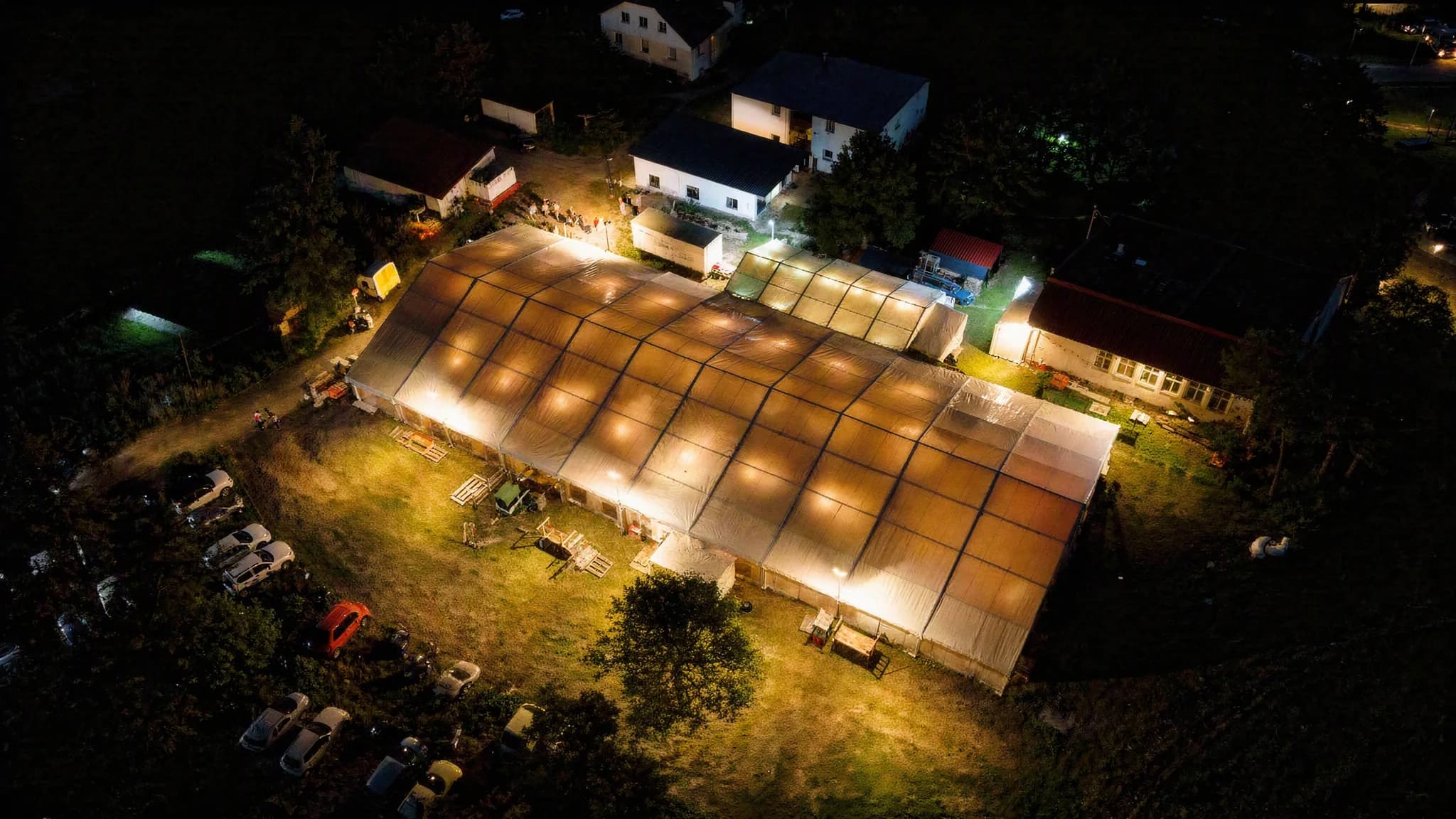 Das beleuchtete Festzelt in Niederwihl bei Nacht, aus der Luft